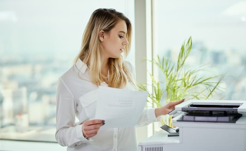 mulher imprimindo documentos representando a locação de impressoras para empresas